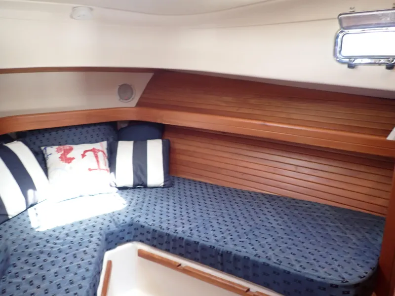 Slide: The Image of 2004 Mainship 34 Rum Runner II cabin with cozy bedding and wooden interior. - 35