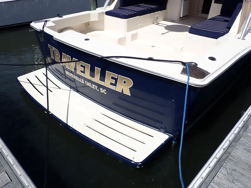 Slide: The Image of 2004 Mainship 34 Rum Runner II docked, featuring "Traveller" name on the stern. - 6