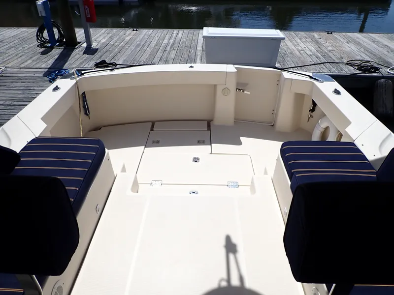 Slide: The Image of 2004 Mainship 34 Rum Runner II boat deck with seating, docked by the water. - 8