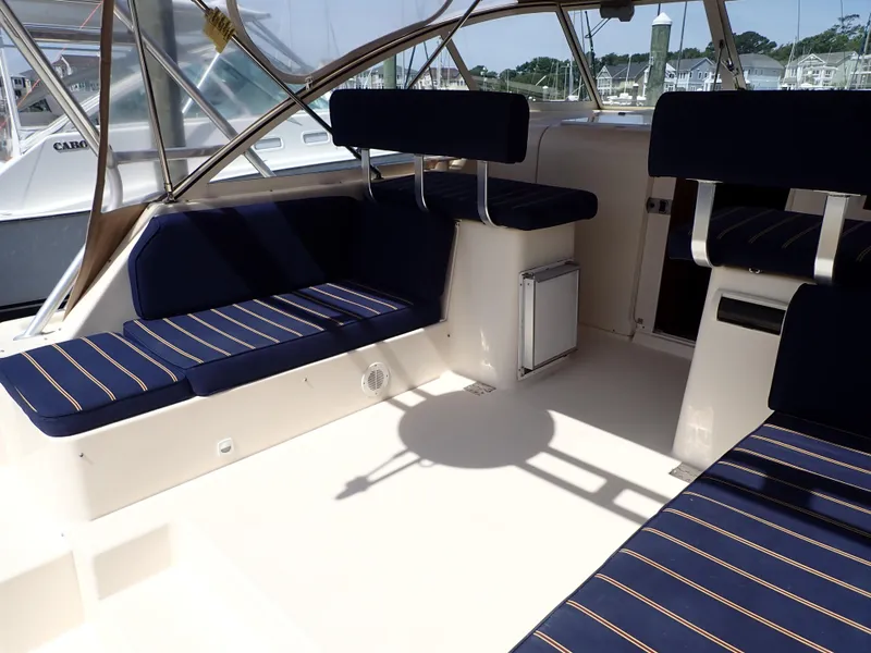 Slide: The Image of 2004 Mainship 34 Rum Runner II interior with blue striped seating and spacious layout. - 9