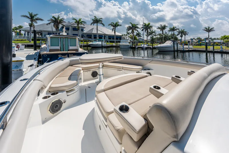 Slide: The Image of 2019 Boston Whaler 420 Outrage boat interior with seating and storage, docked in a sunny marina. - 32