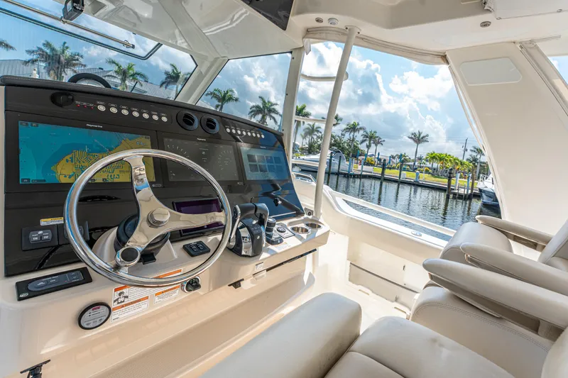Slide: The Image of 2019 Boston Whaler 420 Outrage docked in a sunny marina with palm trees. - 33