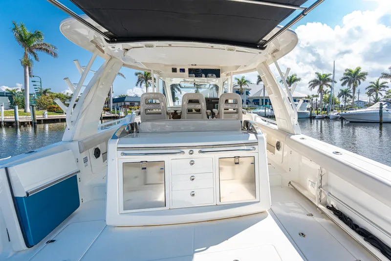 Slide: The Image of 2019 Boston Whaler 420 Outrage docked at marina with palm trees and boats. - 6