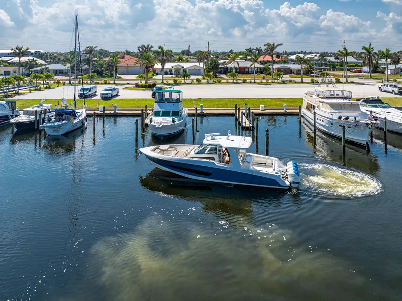 Slide: The Image of 2019 Boston Whaler 420 Outrage docked at a marina under a sunny sky. - 9