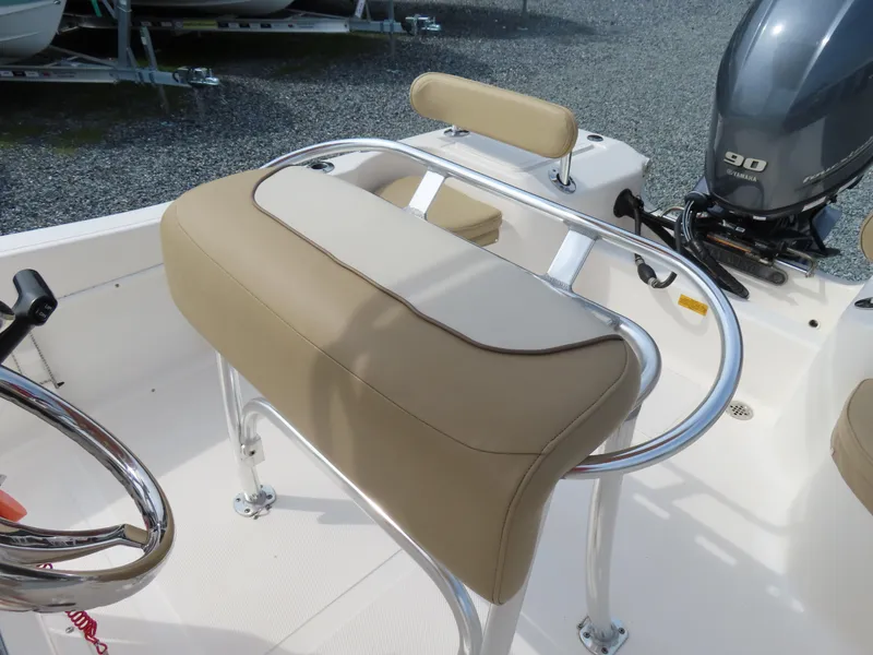 Slide: The Image of 2019 Key West 176 Center Console boat interior with beige seating and steering wheel. - 19