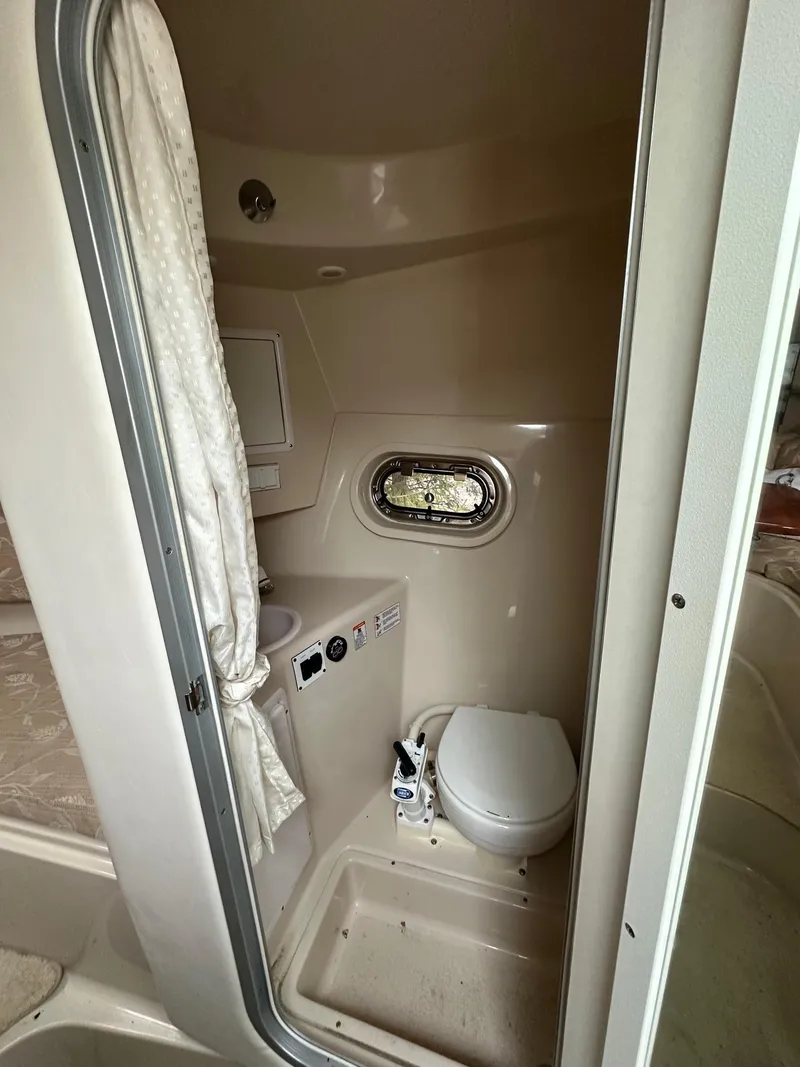 Slide: The Image of 2005 Four Winns 268 Vista boat bathroom with toilet and porthole window. - 11
