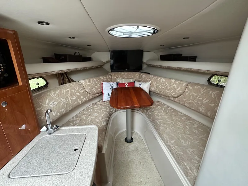Slide: The Image of Interior of 2005 Four Winns 268 Vista boat with cozy seating and compact kitchenette. - 9
