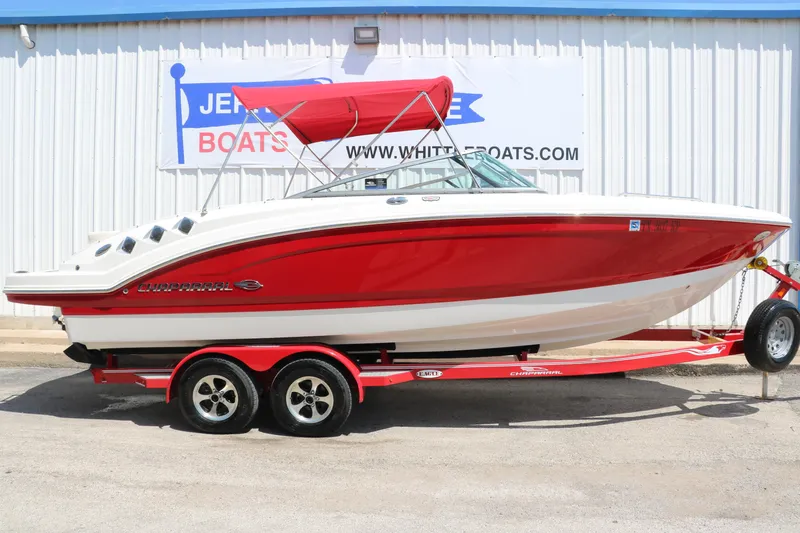 Slide: The Image of 2016 Chaparral 246 SSi boat with red hull and trailer, parked outside a dealership. - 15