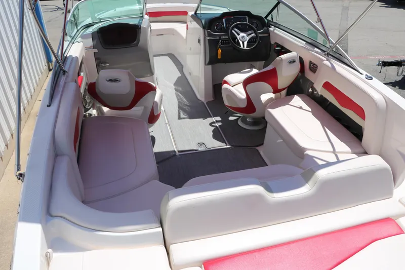 Slide: The Image of 2016 Chaparral 246 SSi boat interior with red and white seating, steering wheel, and spacious layout. - 17
