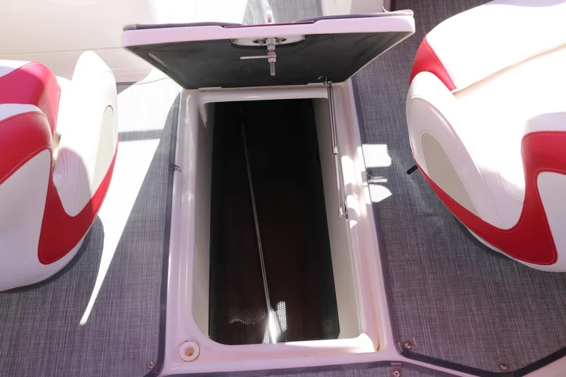 Slide: The Image of 2016 Chaparral 246 SSi boat interior with open storage compartment and red-white seating. - 38