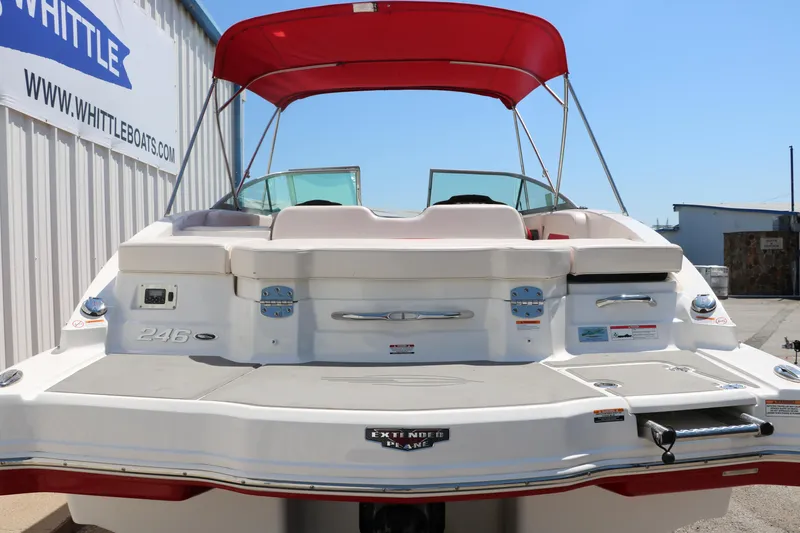 Slide: The Image of 2016 Chaparral 246 SSi boat with red canopy, docked near Whittle Boats building. - 4