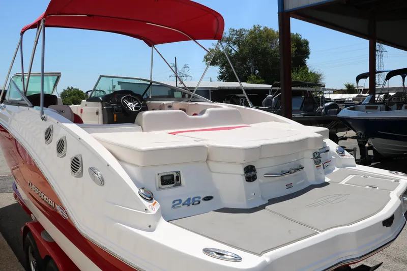 Slide: The Image of 2016 Chaparral 246 SSi boat with red canopy, docked outdoors. - 6