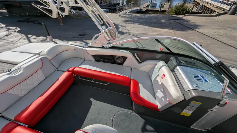 Slide: The Image of 2015 MasterCraft X10 boat interior with red and white seating, docked at marina. - 23
