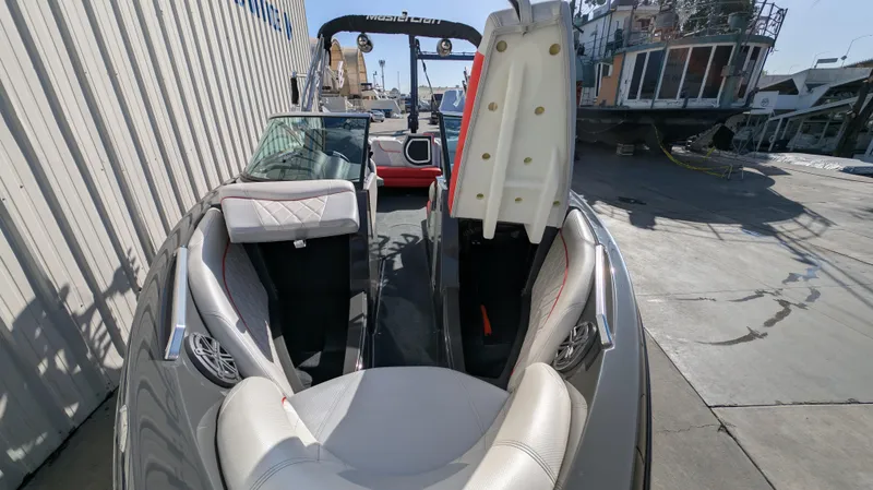 Slide: The Image of 2015 MasterCraft X10 boat interior with open storage compartment, docked outdoors. - 28