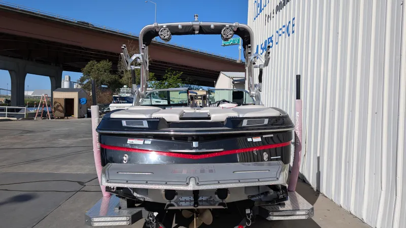 Slide: The Image of 2015 MasterCraft X10 boat parked near a building under a bridge. - 3