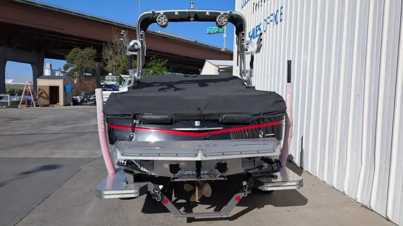 Slide: The Image of 2015 MasterCraft X10 boat with cover, parked near a building and underpass. - 35