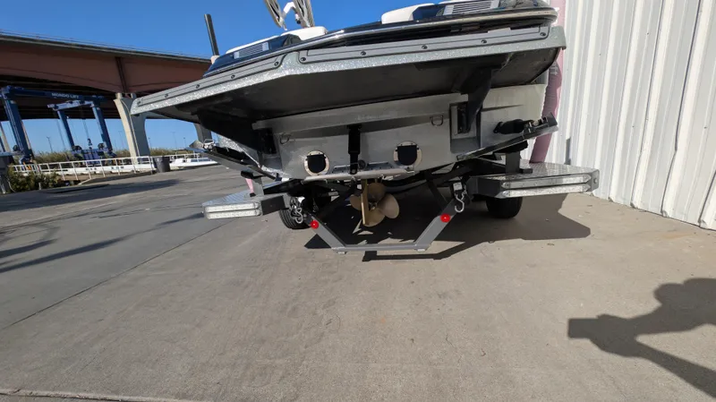 Slide: The Image of 2015 MasterCraft X10 boat on trailer, rear view, parked near a building. - 4