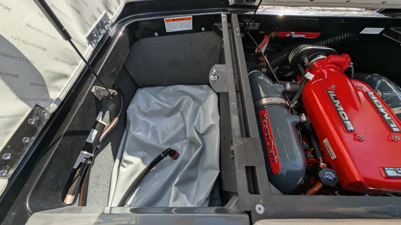 Slide: The Image of 2015 MasterCraft X10 engine compartment with red Ilmor engine and storage space. - 49