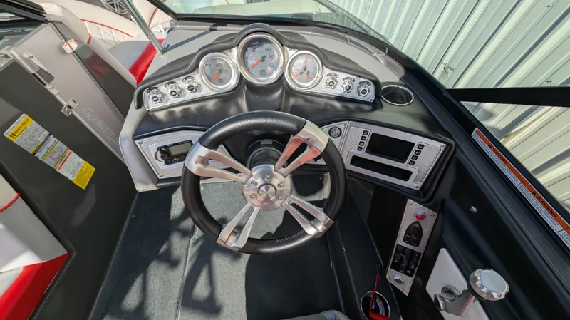 Slide: The Image of 2015 MasterCraft X10 boat dashboard with steering wheel and control panel. - 6