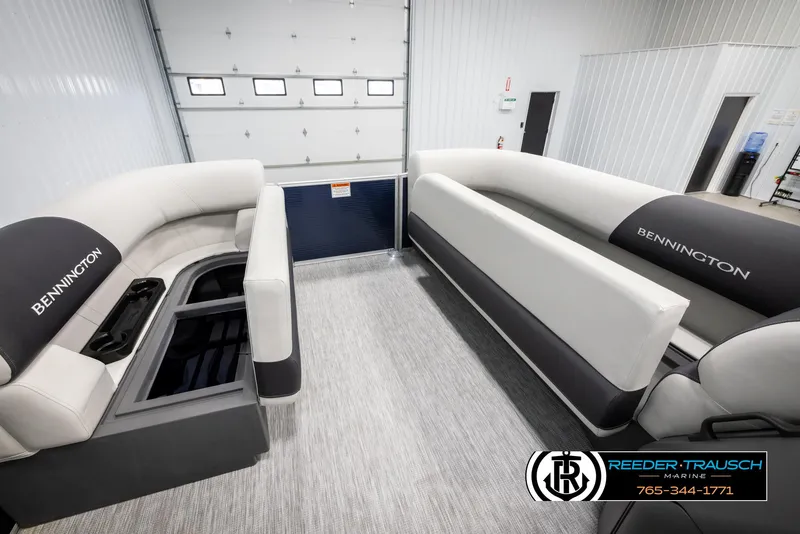 Slide: The Image of 2025 Bennington 20 SLSE pontoon boat interior with plush seating in a showroom. - 20