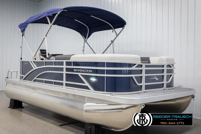 Slide: The Image of 2025 Bennington 20 SLSE pontoon boat with blue canopy in showroom. - 3