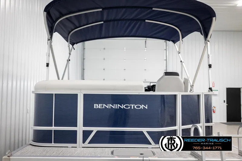 Slide: The Image of 2025 Bennington 20 SLSE pontoon boat with blue exterior and canopy in showroom. - 7