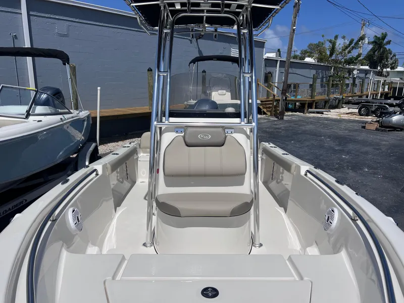 Slide: The Image of 2024 Key West 189 FS boat interior with seating and console, parked outdoors. - 13