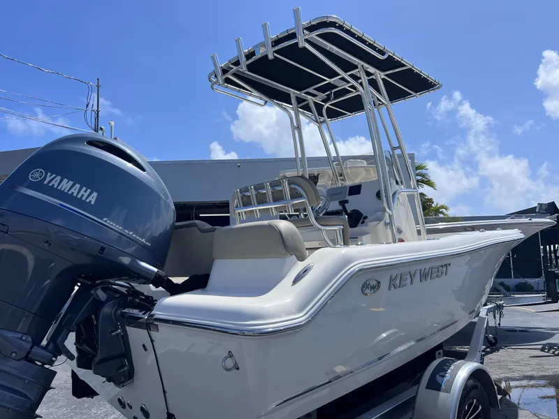 Slide: The Image of 2024 Key West 189 FS boat with Yamaha engine, parked on a trailer under a clear blue sky. - 6