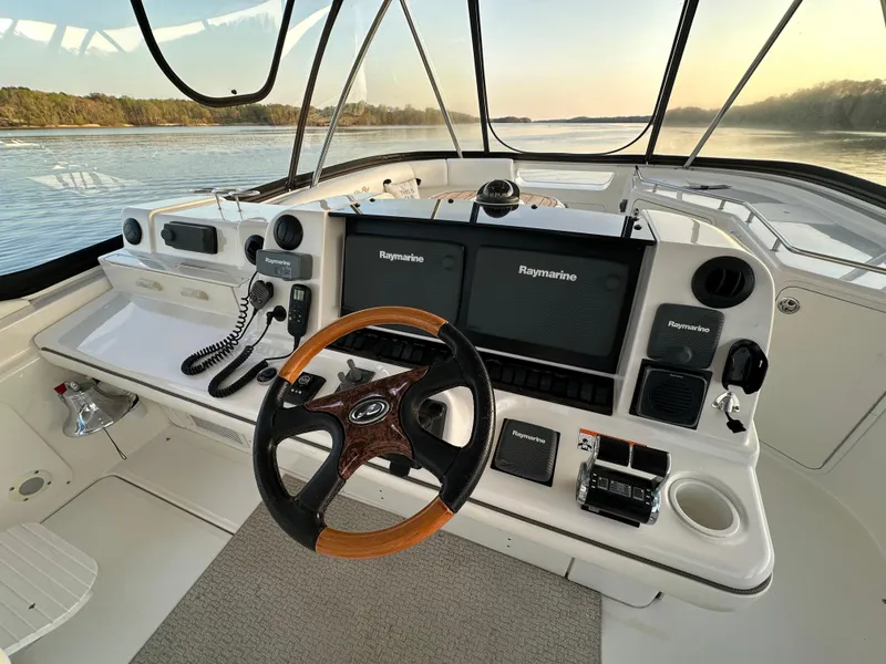 Slide: The Image of 2006 Sea Ray 58 Sedan Bridge helm with Raymarine electronics and wooden steering wheel. - 2