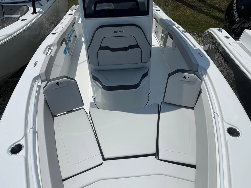 Slide: The Image of 2025 Sea Pro 245 Sandbar boat interior with seating and console, showcasing modern design. - 12