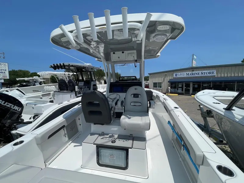 Slide: The Image of 2025 Sea Pro 245 Sandbar boat interior with seating and console, displayed at a marine store. - 9