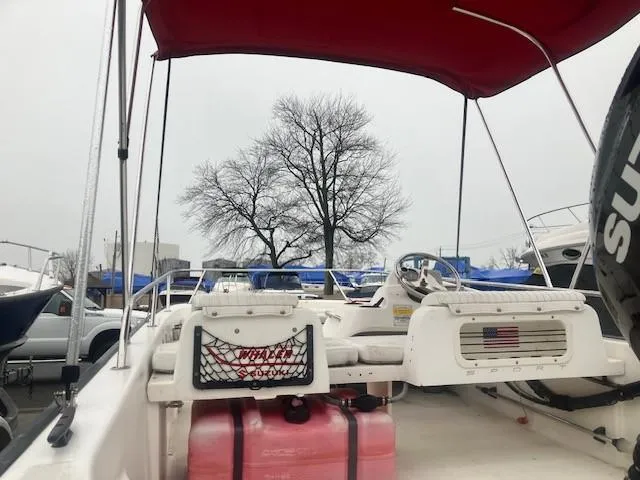 Slide: The Image of 2003 Boston Whaler 150 Sport boat with red canopy and visible fuel tank. - 2