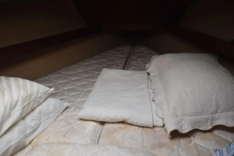 Slide: The Image of Cozy cabin bed inside 1983 S2 Sloop sailboat with pillows and bedding. - 10