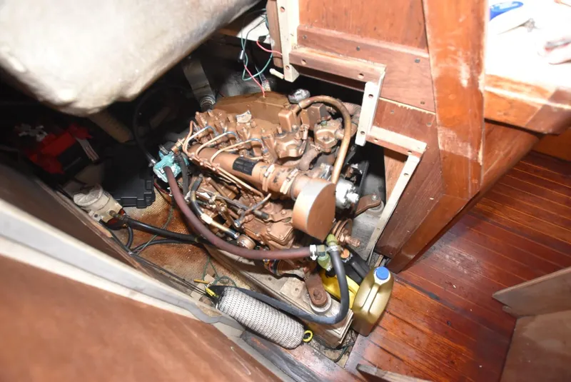 Slide: The Image of 1983 S2 Sloop engine compartment with visible mechanical components and wooden interior. - 13