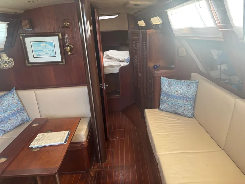Slide: The Image of 1983 S2 Sloop interior with wooden finish, seating, and nautical decor. - 17