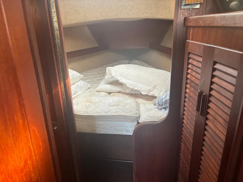 Slide: The Image of 1983 S2 Sloop cabin interior with cozy bed and wooden furnishings. - 18