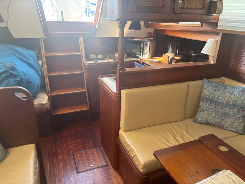 Slide: The Image of 1983 S2 Sloop interior with wooden finish, cozy seating, and compact kitchen area. - 19