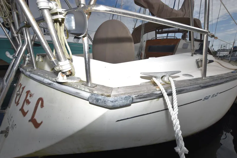 Slide: The Image of 1983 S2 Sloop sailboat docked, featuring a clean deck and mooring ropes. - 4