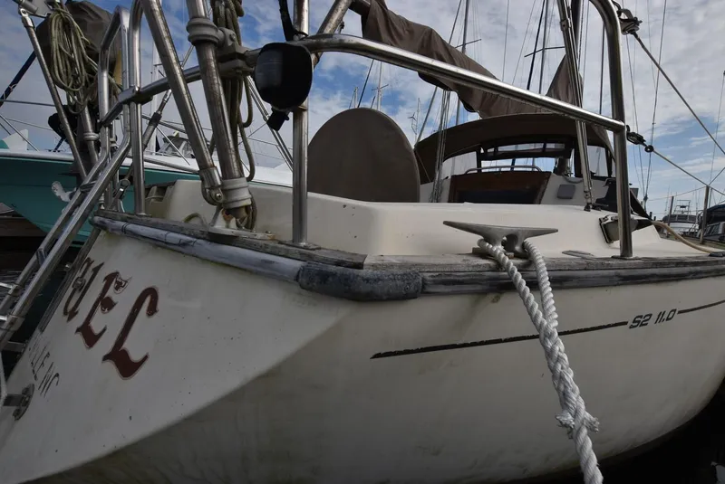 Slide: The Image of 1983 S2 Sloop sailboat docked, featuring a sturdy rope and metal railings. - 5