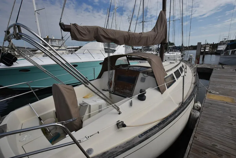 Slide: The Image of 1983 S2 Sloop sailboat docked at marina, featuring covered cockpit and sleek design. - 6