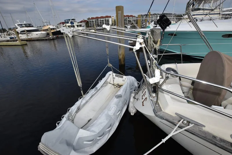 Slide: The Image of S2 Sloop 1983 with dinghy at marina, surrounded by other boats. - 7