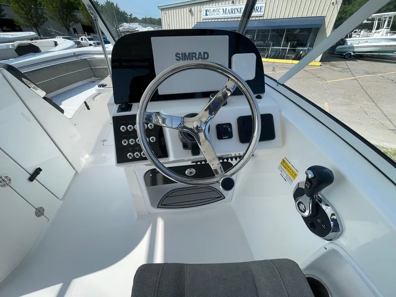 Slide: The Image of 2025 Sea Pro 240 Dual Console boat dashboard with steering wheel and controls. - 11