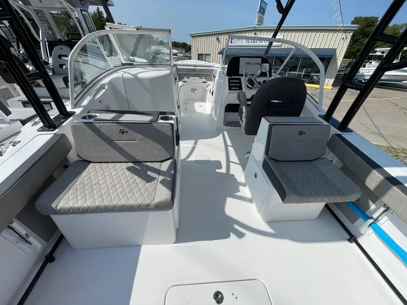 Slide: The Image of 2025 Sea Pro 240 Dual Console boat interior with seating and helm, docked outdoors. - 17
