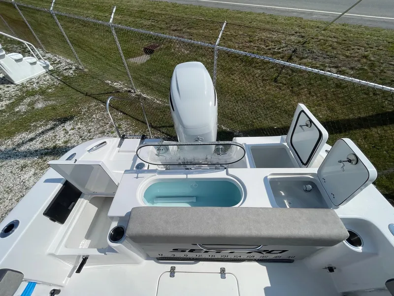 Slide: The Image of 2025 Sea Pro 240 Dual Console boat with open storage compartments and seating. - 26