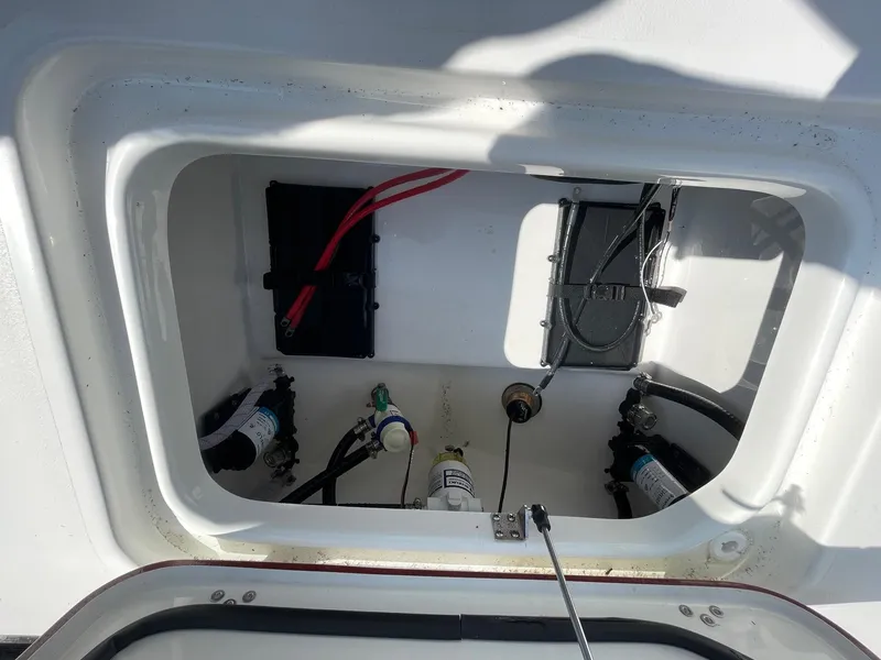 Slide: The Image of 2025 Sea Pro 240 Dual Console storage compartment with wiring and equipment. - 29