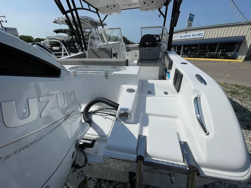 Slide: The Image of 2025 Sea Pro 240 Dual Console boat with Suzuki engine, docked near a marine store. - 5