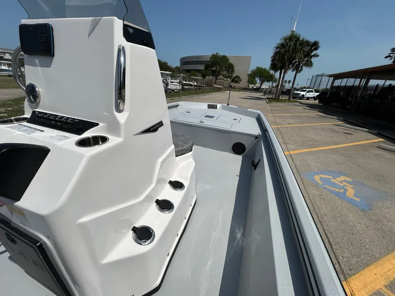 Slide: The Image of 2025 Avid 20 ROGUE CC boat, white console, docked near parking lot with palm trees. - 11