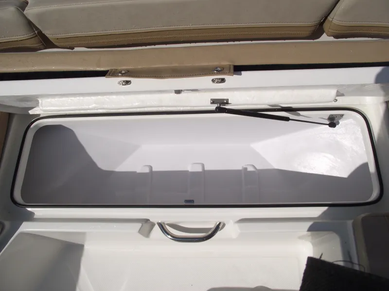 Slide: The Image of 2025 Bayliner Trophy T22SC storage compartment with open lid, showcasing interior space. - 12