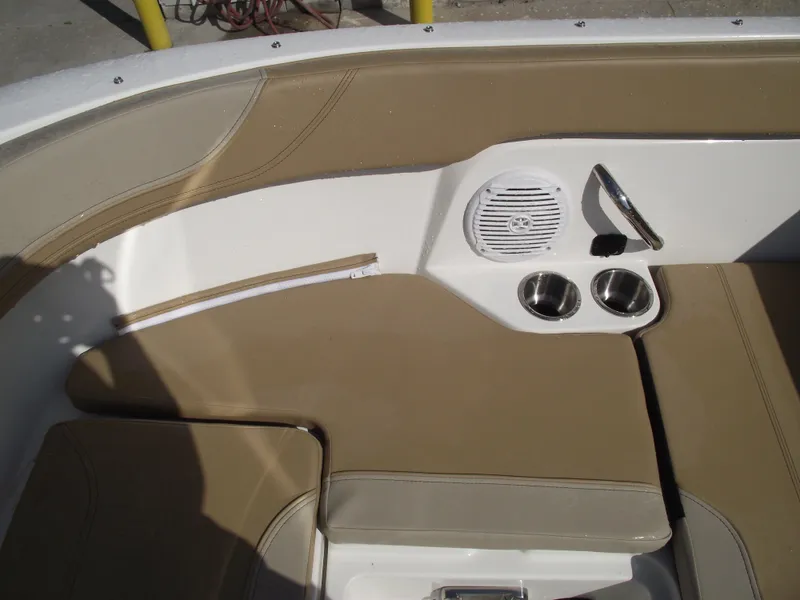 Slide: The Image of 2025 Bayliner Trophy T22SC boat interior with beige seating, cup holders, and speaker. - 13