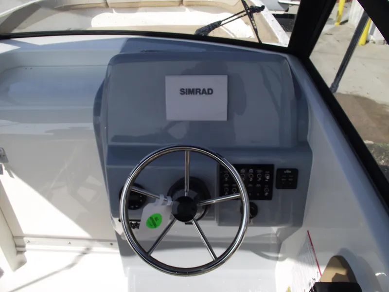 Slide: The Image of 2025 Bayliner Trophy T22SC helm with Simrad navigation system and steering wheel. - 22
